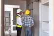 © amnaj - Two Asian male engineers are inspecting a job site and looking at drawings, consulting and debugging works to achieve quality work.