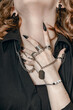 Hand with long black nails and gothic style rings around the neck