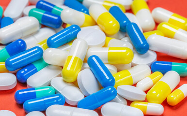 Wall Mural - Colored pills, pills and capsules on a red background