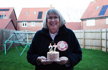 Lady Happily Celebrating Her 72nd Birthday With Cake And Candles