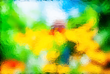 Blurred Natural Background. Abstract Image Of Yellow Flowers Seen Through Wet Glass. Water Drops