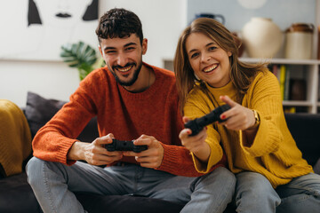 A happy couple plays a video game with a joystick