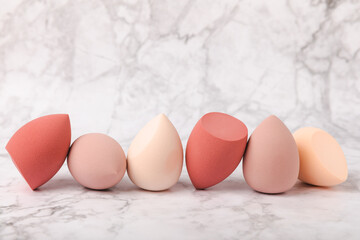 beauty blender on light marble background. cosmetics, makeup application tool. beauty concept. copy 