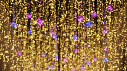 Wall Mural - Defocused vertical LED garlands at night. Blurred glowing golden lights. 