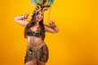 Beautiful Brazilian woman in golden carnival clothes, wearing carnival dancer feather crown. peace and love, pose for selfie.