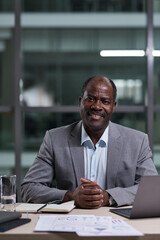Poster - Successful mature African American male director of business company looking at camera while sitting by workplace with computer