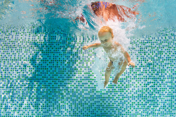 Wall Mural - Happy child dive underwater with fun in swimming pool