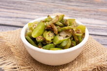 Grilled Okra, In A White Bowl On A Wooden Table, Focused, Isolated