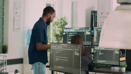 Asian programer developing database interface and writing server code, working in software development office. System engineer creating algorithm on terminal window. Handheld shot.