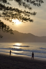 silhouette of two people playing beach volleyball on the beach and sand. With the background of the sunset on the beach