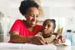 © Wavebreak Media - Happy african american grandmother and blind granddaughter reading braille