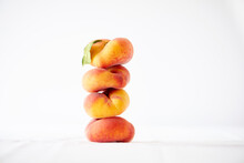 Stack Of Peaches Against White Background