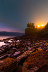 Canvas Print - starry night sky around the rocky shore.