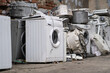 Appliance recycling concept. Old used washing machines on street. E-waste at landfill, local scrap yard
