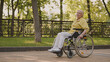 © Synthex - Senior woman with disability sitting in wheelchair in park, social care and protection