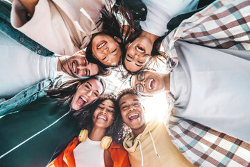 Multicultural community of young people smiling at camera outside - International university students taking selfie picture together - Friendship concept with guys and girls having fun on city street