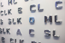 Letters Of The English Alphabet In Silver Color On A Light Wall