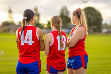Three Female Teammates In Football Uniforms At Training