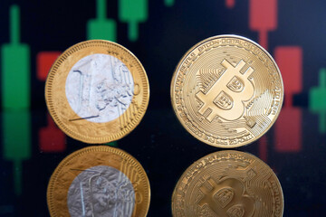 Bitcoin gold coin and one euro coin on chart background. Virtual cryptocurrency vs tradition currency concept