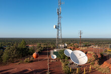 Aerial View Of Satellite Dishes At The Base Of A Communications Tower In A Barren Outback Setting