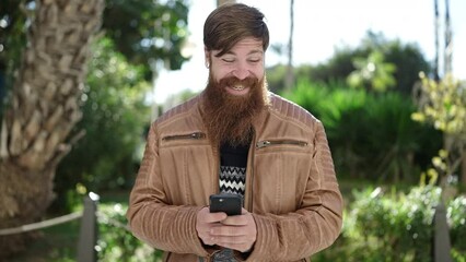 Sticker - Young redhead man smiling confident using smartphone at park