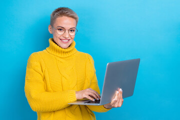 Wall Mural - Photo of intelligent adorable lady wear stylish yellow winter sweater use netbook near empty space isolated on blue color background