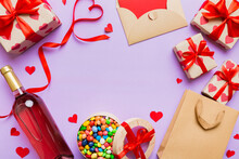 Top View Photo Of St Valentine Day Decor Shopping, Bag, Wine, Bottle, Envelope, Gift, Box, Candy And Red Heart On Colored Background With Empty Space. Frame Background
