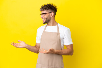 Wall Mural - Restaurant waiter blonde man isolated on yellow background with surprise facial expression