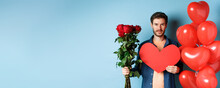 Valentines Day Romance. Young Man With Bouquet Of Red Roses And Heart Balloons Smiling, Bring Presents For Lover On Valentine Date, Standing Over Blue Background