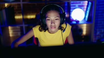 Poster - Young african american woman streamer playing video game with winner expression at gaming room