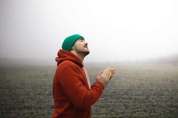 a man in the fog prays to god. prayer to god. believer.