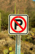 © Aaron - No parking sign with red and black paint on white background with metal pole holding it up in late afternoon sun