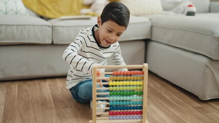 Canvas Print - Adorable hispanic boy playing with abacus sitting on floor at home