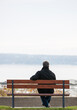 © Pierre - Rear view of mature man overlooking river in Autumn alone.