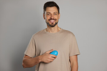 Poster - Handsome man using fabric shaver on light grey background