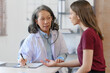 © NanSan - Female elder doctor takes a history of a patient and gives a consultation about osteopathy to a female patient after measuring blood pressure and heart rate and encouragement by holding hands