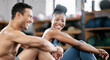 © J Maas/peopleimages.com - Fitness, relax or personal trainer with a happy client at gym for training, exercise or body workout. Team partnership, funny coach or tired black woman resting, laughing or bonding on break together