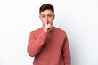© luismolinero - Young handsome Brazilian man isolated on white background showing a sign of silence gesture putting finger in mouth