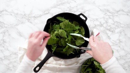 Canvas Print - Flat lay. Sauteeing spinach for spinach and ham frittata.