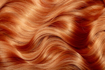 Wall Mural - Red hair close-up as a background. Women's long orange hair. Beautifully styled wavy shiny curls. Hair coloring bright shades. Hairdressing procedures, extension.