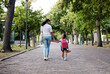 © Nina/peopleimages.com - Walking, park and mother holding hands with girl on journey for back to school, learning and class for first day. Love, black family and mom with child walk for kindergarten, education and play date