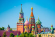 Spasskaya Tower of Moscow Kremlin and domes of the Cathedral of Vasily the Blessed (Saint Basil's Cathedral) on Red Square in sunny summer day. Moscow. Russia