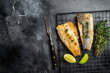 Grilled sea bass fillet with lime and thyme. Black background. Top view. Copy space
