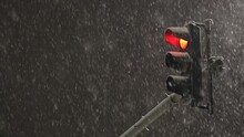 Red Traffic Light On A Pole. 4k Video During A Winter Night With Massive Snowfall. Transportation Infrastructure Industry.
