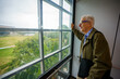 © Felix Mizioznikov - PHoto of a college professor looking out of an elevator window view