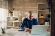 © Zamrznuti tonovi - Middle aged man working in a home office and using laptop