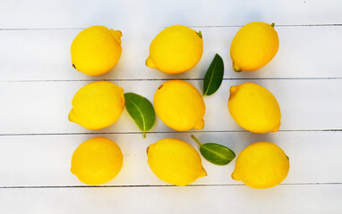 Wall Mural - Fresh ripe yellow lemon fruits on a  on a white wooden background.Healthy eating or diet concept with space for text.Top view.Selective focus.