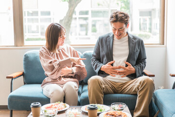 Poster - カフェで満腹まで食べる男性と笑う女性（大食い・食べ放題・バイキング・ビュッフェ・アジア人・男女）