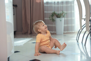 Wall Mural - Cute baby sitting on floor in room. Learning to walk