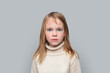 © millaf - Portrait of serious funny little girl looking at camera on grey background